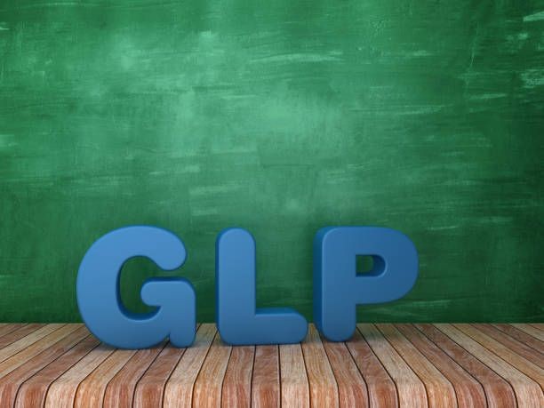 3D blue letters 'GLP' on a wooden floor with a green chalkboard background.